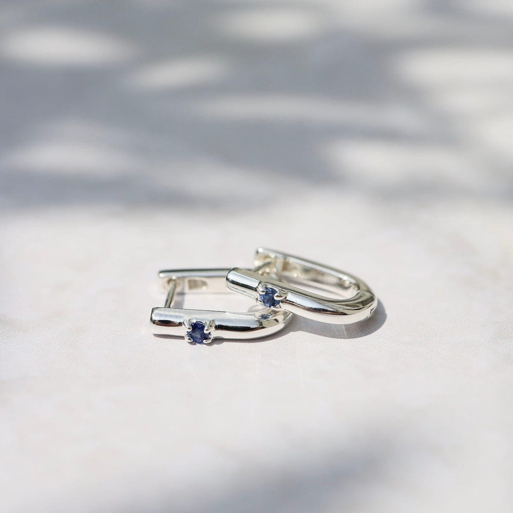 
                      
                        EAR U Shaped Huggie Hoops with Blue Sapphire in Sterling Silver
                      
                    