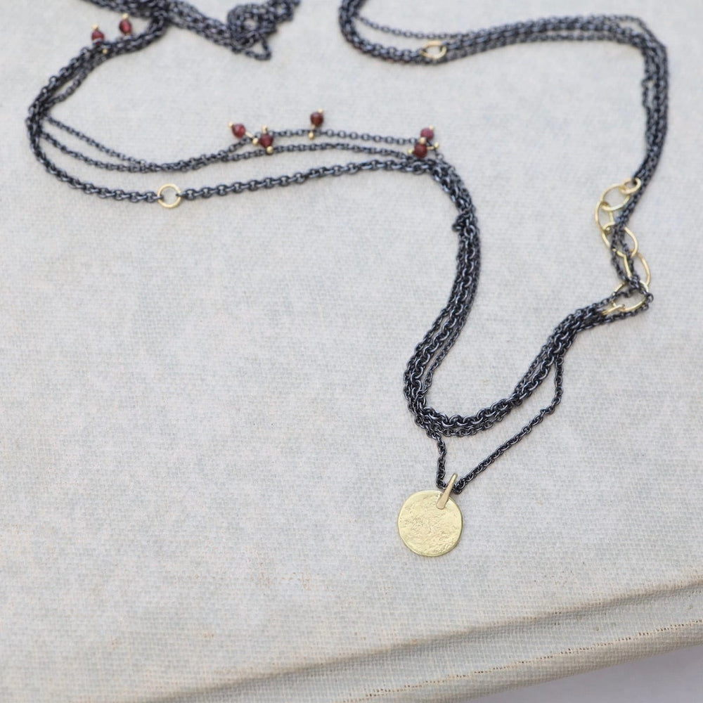 
                  
                    NKL-18K Parchment Disk Triple Chain Necklace with Garnets
                  
                