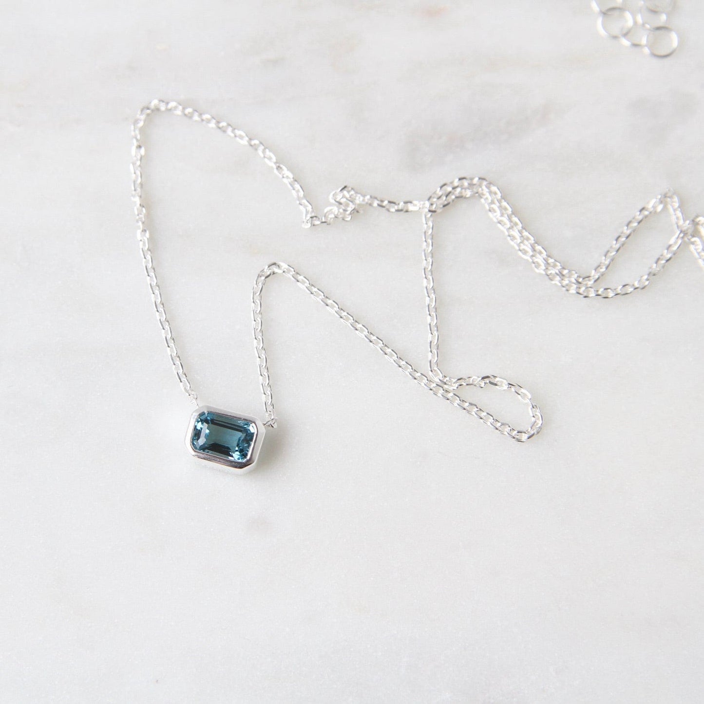 Load image into Gallery viewer, NKL Bezel Set Emerald Cut London Blue Topaz Solitaire Necklace
