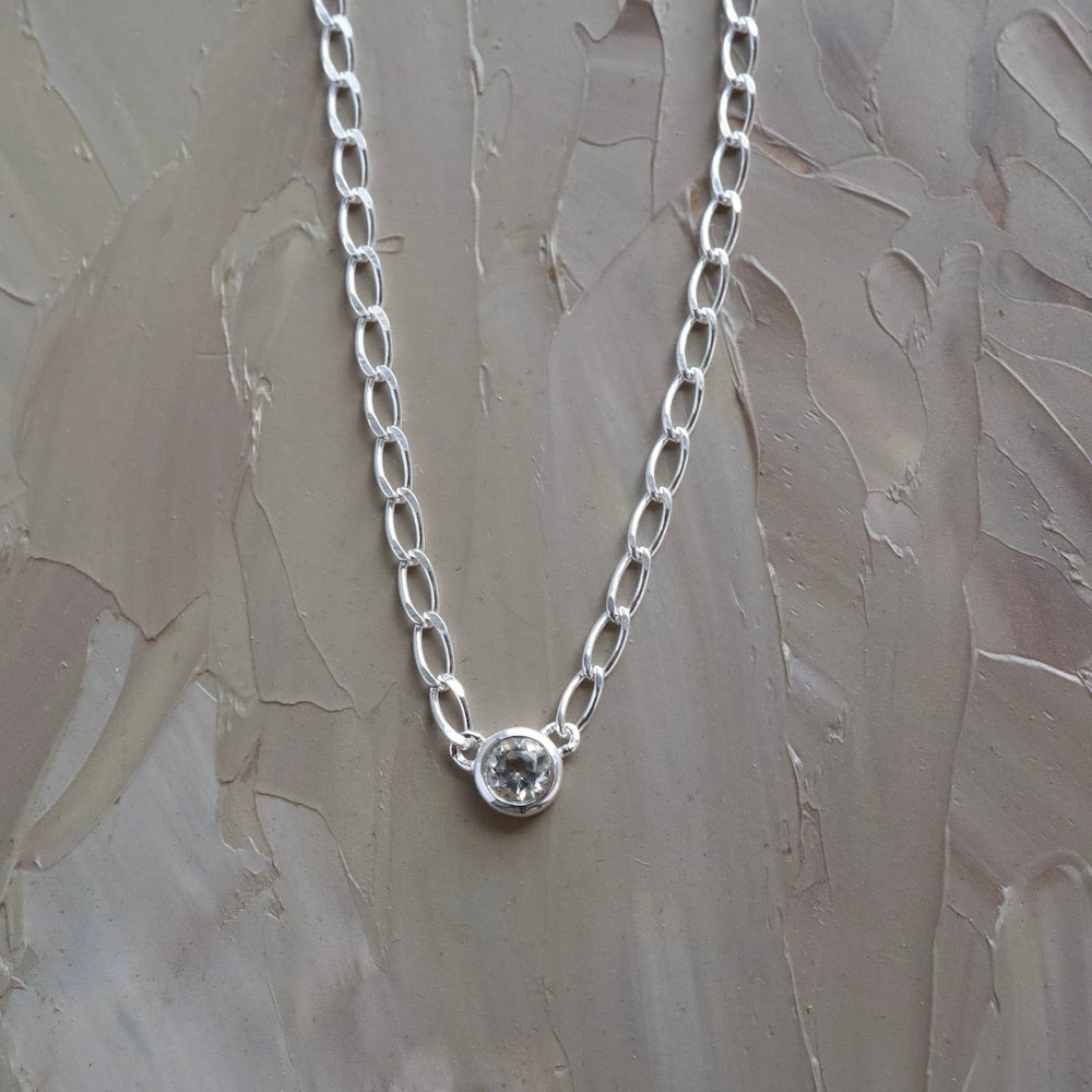 
                  
                    NKL Bezel Set Round White Topaz on Sterling Silver Cut Curb Chain
                  
                