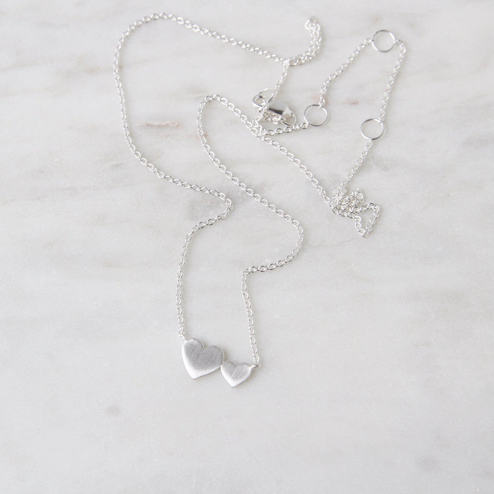 
                      
                        NKL Brushed Sterling Silver Big & Little Hearts Necklace
                      
                    