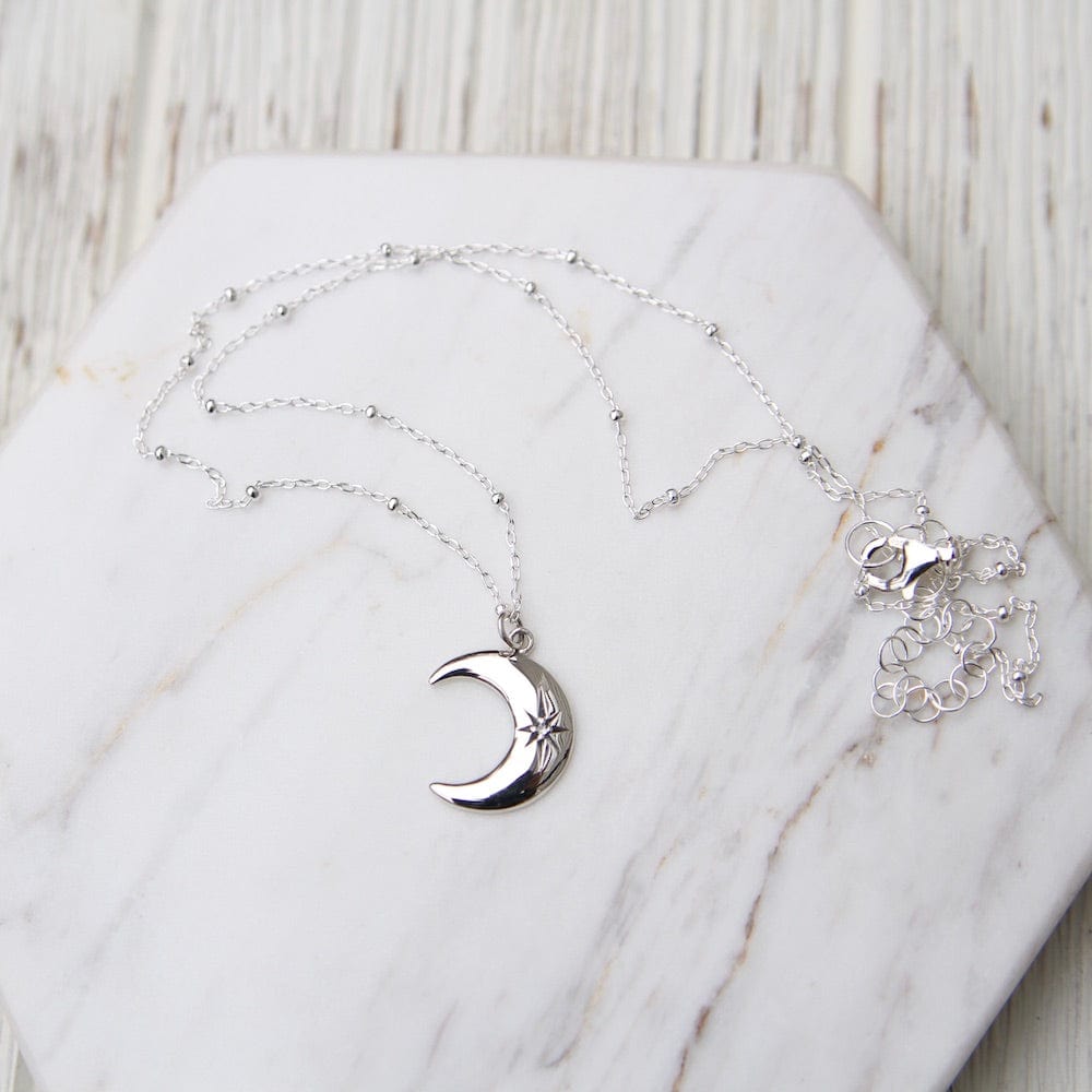 
                      
                        NKL Crescent Moon with Star Set White Sapphire
                      
                    