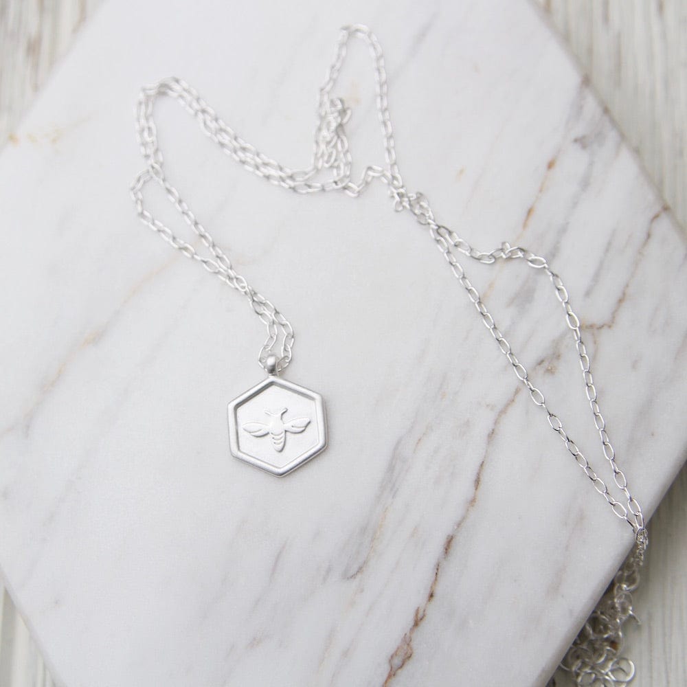 
                      
                        NKL Hex with Bee Necklace - Brushed Sterling Silver
                      
                    