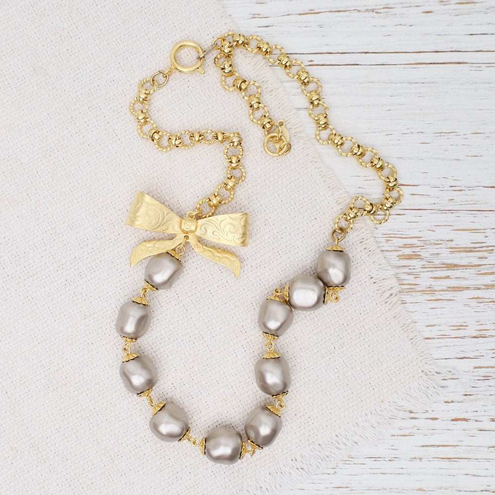 
                  
                    NKL-JM Grey Glass Pearl and Bow Necklace
                  
                