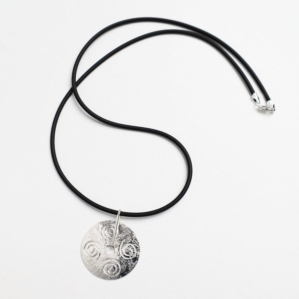 
                  
                    NKL Round Disc Pendant with Swirls on Black Cord
                  
                
