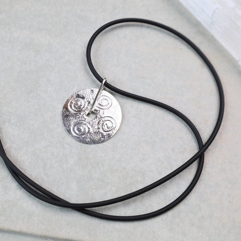 
                  
                    NKL Round Disc Pendant with Swirls on Black Cord
                  
                