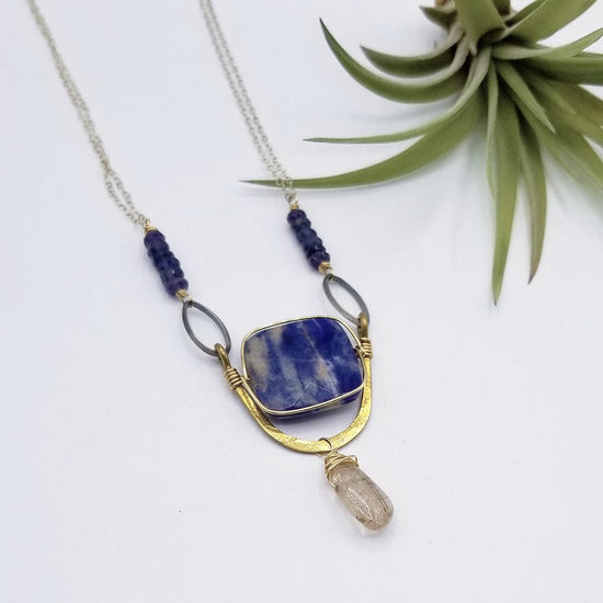 Load image into Gallery viewer, NKL SODALITE SQUARE SET IN A BRASS &amp;quot;U&amp;quot; WITH RUTILATED QUARTZ DROP NECKLACE

