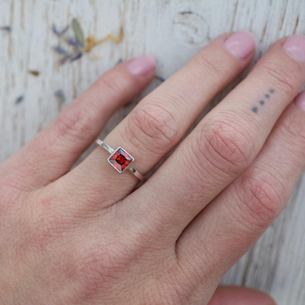 
                      
                        RNG Bezel Set Square Red CZ Silver Ring
                      
                    