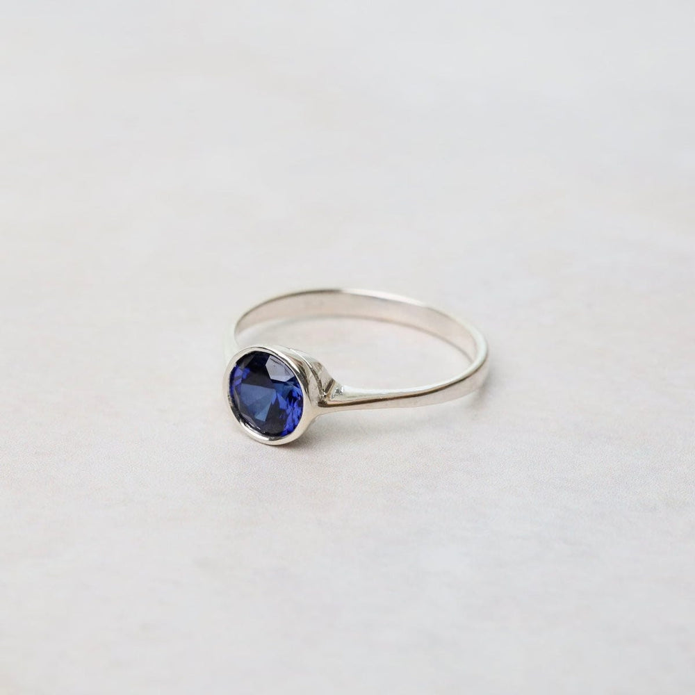 
                      
                        RNG Sterling Silver Ring with 6mm Round Bezel Set Synthetic Sapphire
                      
                    